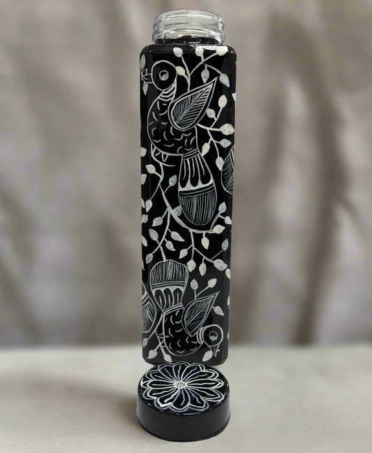 Black and white patterned water bottle on a table with a blurred background