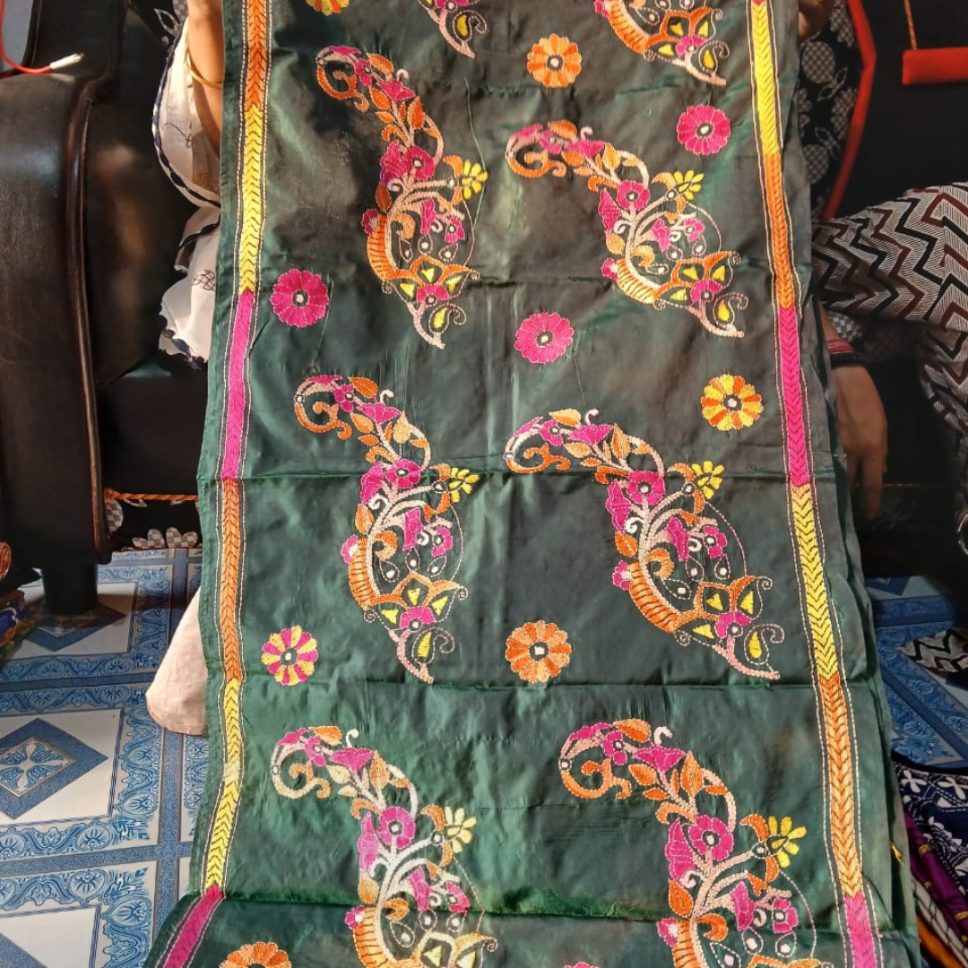 Green silk stole with vibrant multicolor floral and paisley hand embroidery, bordered with pink, yellow, and orange threadwork.