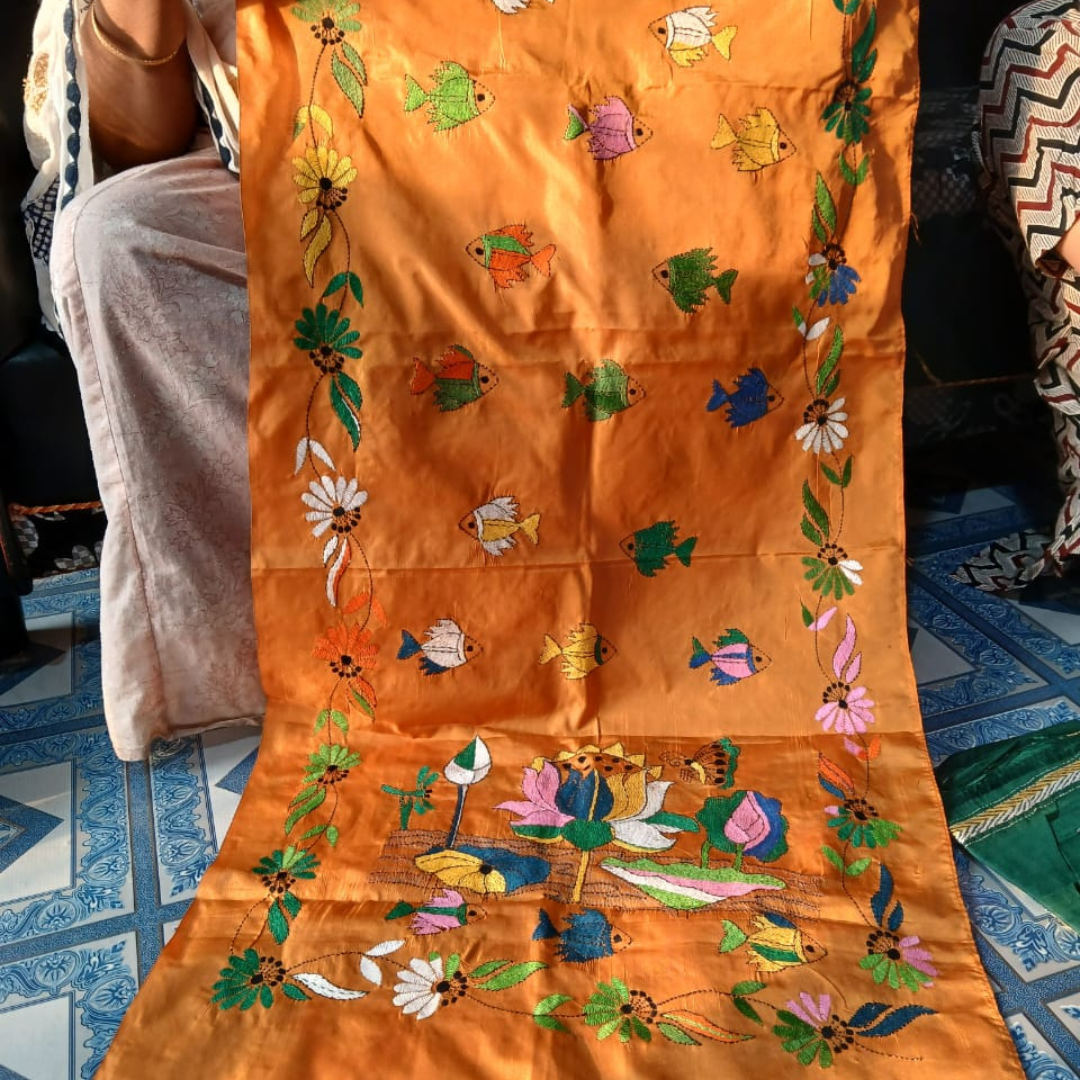 Orange Tussar silk stole featuring a beautiful hand-embroidered design of fish and lotus flowers.
