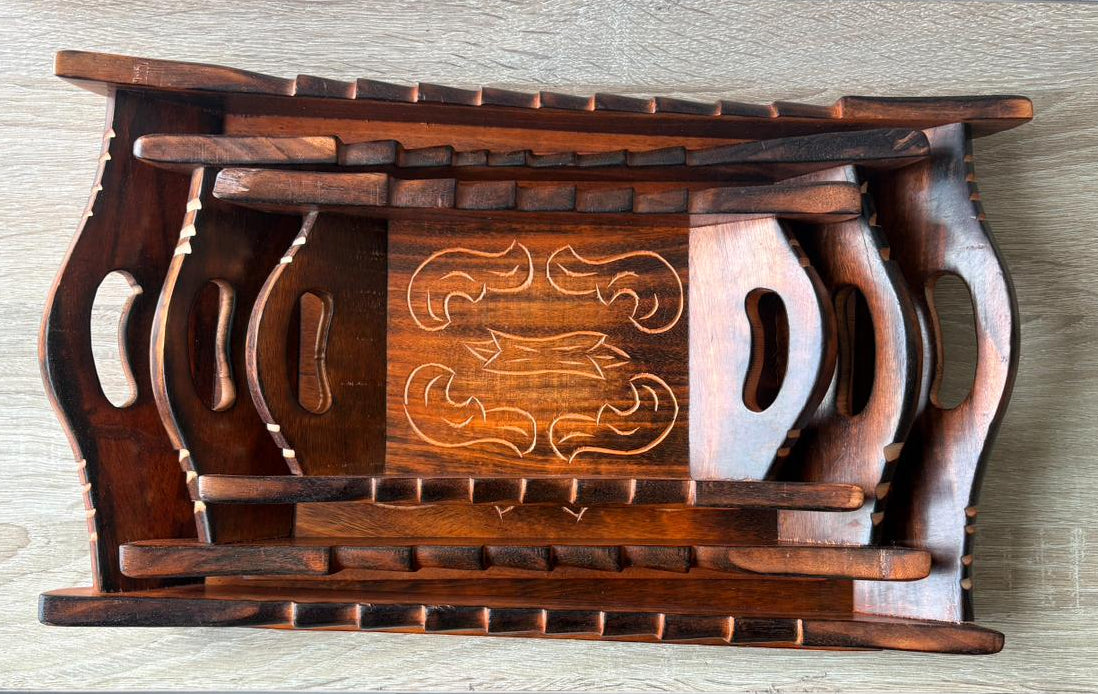 Wooden tray with intricate carvings on a light wooden surface