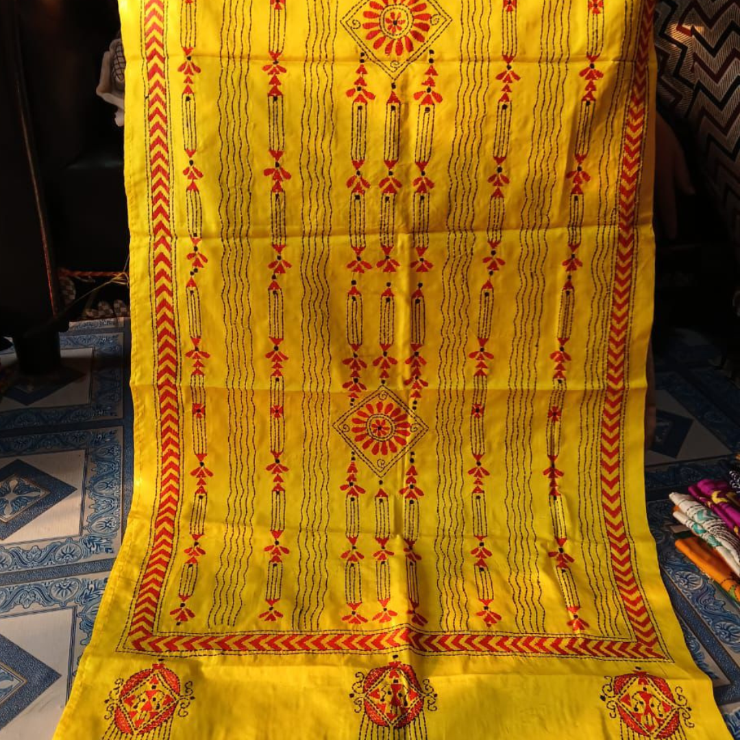 Bright yellow stole with red and black geometric and floral patterns.