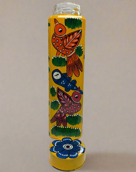Decorative glass bottle with colorful art on a white surface