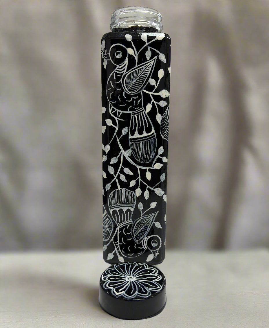 Black and white patterned water bottle on a table with a blurred background