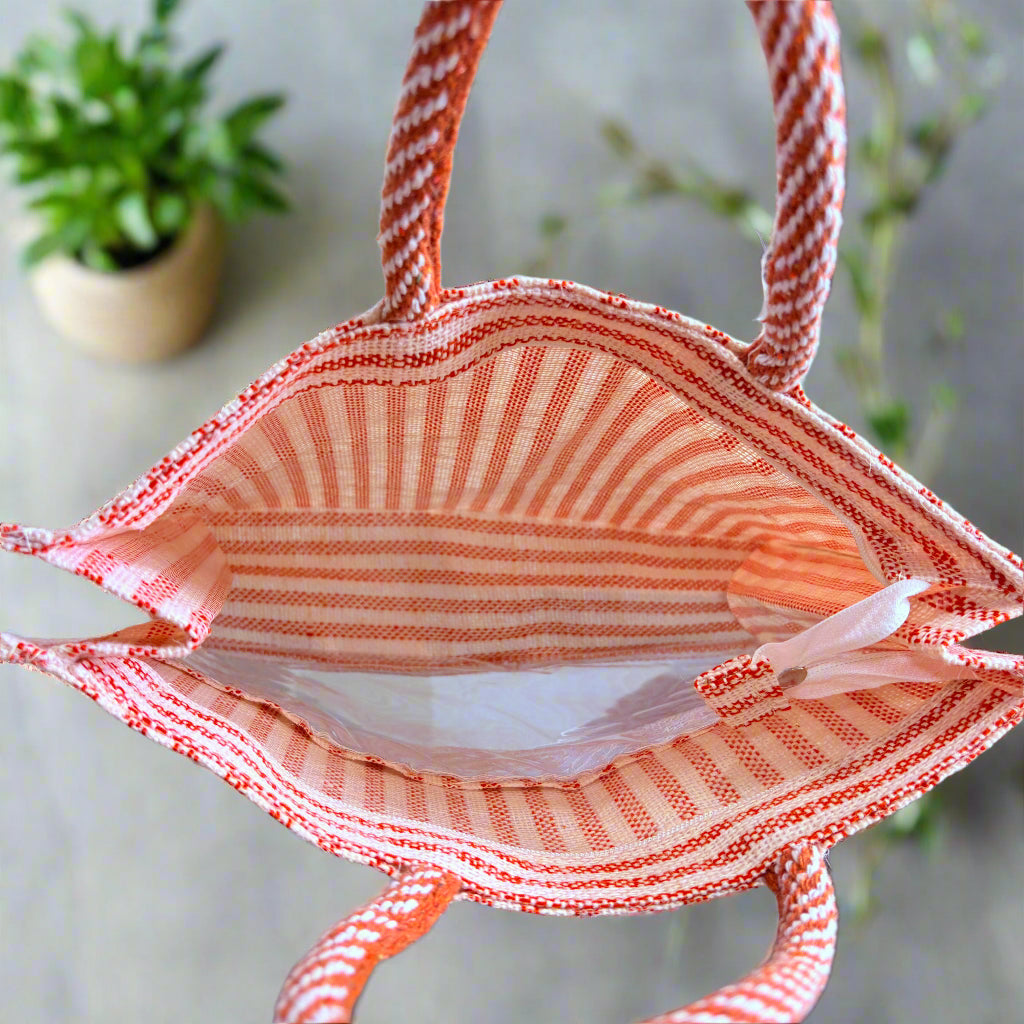 Red and white striped bag on a reflective surface with a blurred background