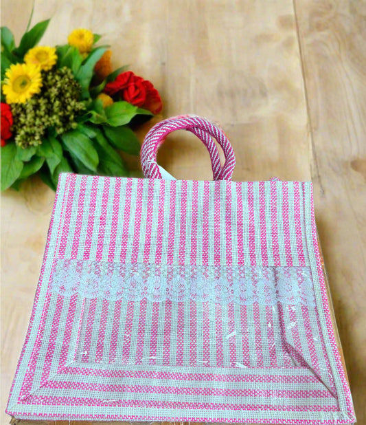 Pink and white striped bag with a handle on a wooden surface