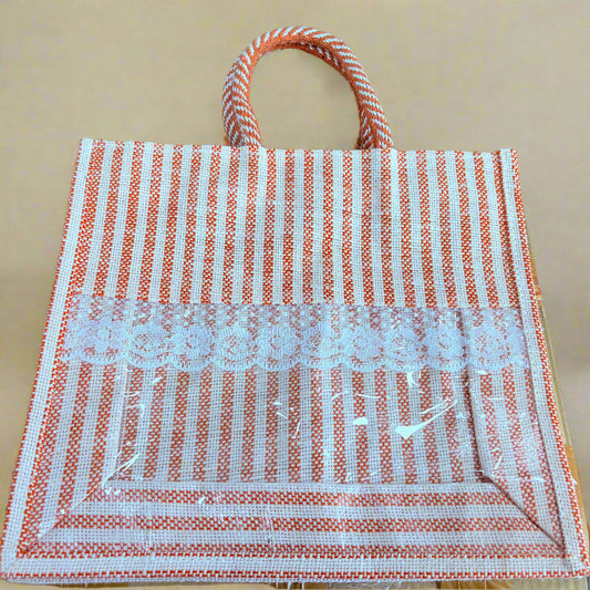 Striped bag with a lace patch on a wooden surface