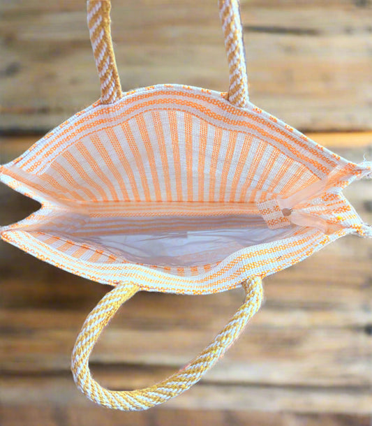 Striped bag with yellow handle on a tiled floor